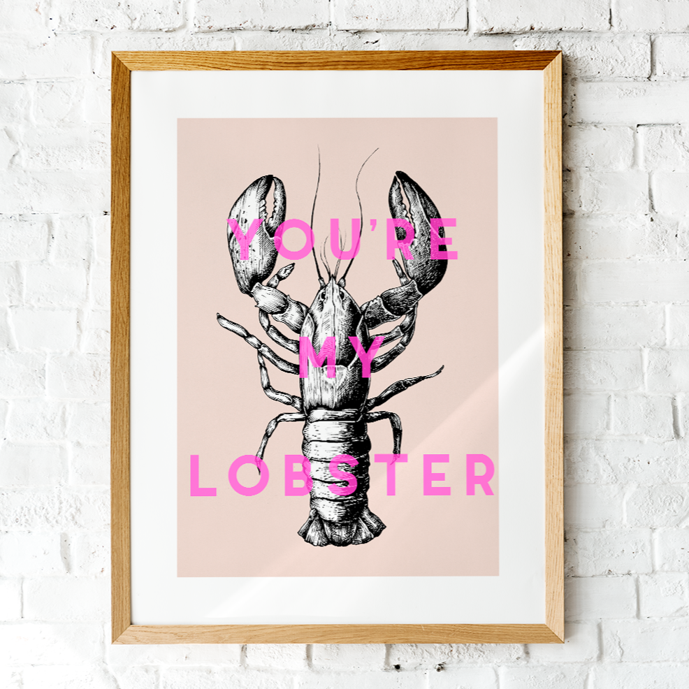 You're My Lobster Unframed Art Print in a wooden frame hung on a white brick wall
