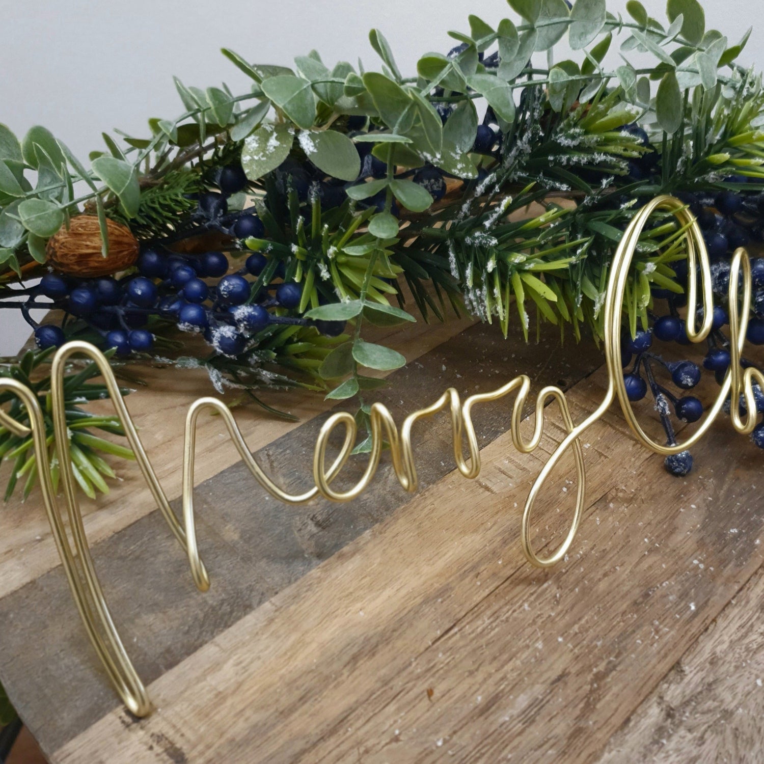 Gold Merry Christmas Wire Word Christmas Wreath Sign for Christmas Decoration as a table centrepiece surrounded by a frosted berry garland